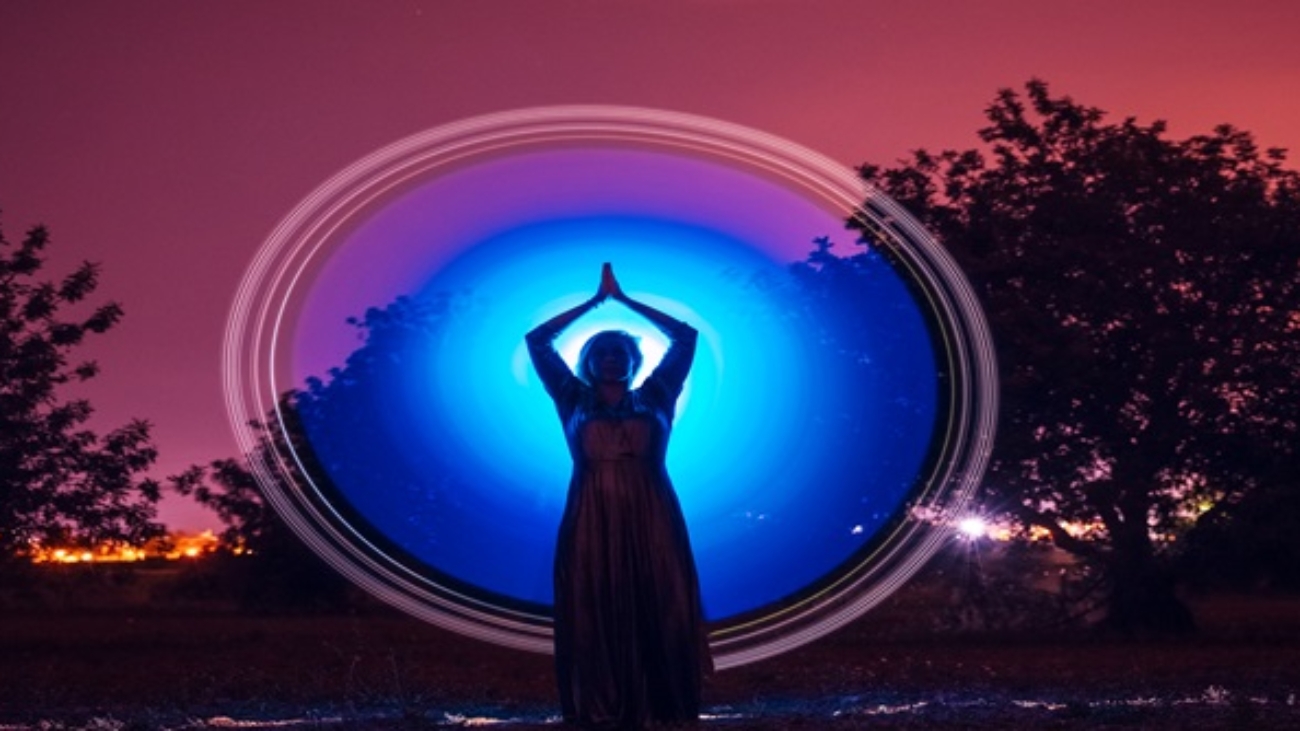 Female silhouette in glowing circle in nature
